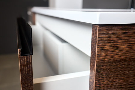 Sliding lockers with black aluminum extruded G profile handles for bathroom kitchen cabinets. Solutions for placing things in bathroom horizontal sliding pull out drawer shelves storage of cupboard.の写真素材