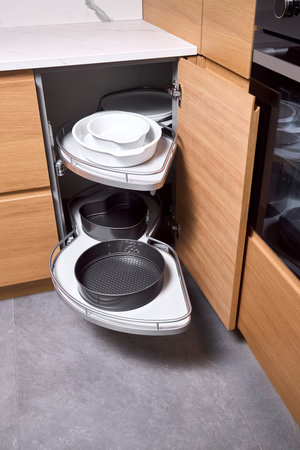 Kitchen access mechanism Magic corner for Blind Corner Cabinets pushed inside right cabinet. Solution for a kitchen corner storage in cupboard. Corner unit with pull out shelves for cookware.の写真素材