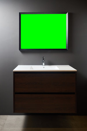 Stand with sink and supplies near dark tiled wall in bathroom with dim lights semi darkness twilight and mirror with frame, copyspace. Contemporary bathroom detail rustic loft interior concept.の写真素材