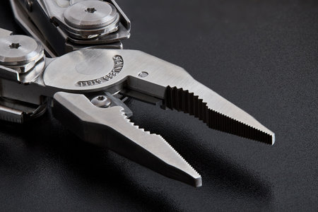 Pliers multi tool parts close up parts pivot point or fulcrum, pipe grip, tip, jaws or nose and handles. Pliers can grip, band, cut, and manipulate various materials. Focus stacking shot over black.の写真素材