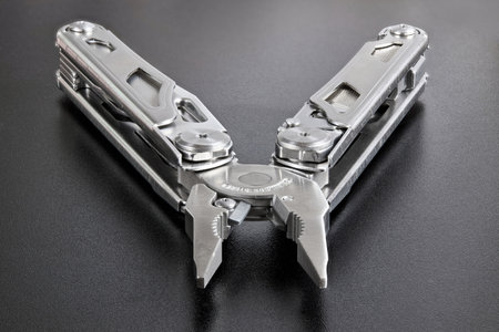 Pliers multi tool close up parts pivot point or fulcrum, pipe grip, tip, jaws or nose and handles. Pliers can grip, band, cut, and manipulate various materials. Focus stacking shot over black.の写真素材