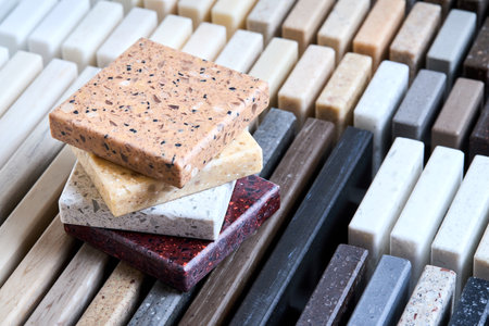 Porcelain stoneware artificial stone square samples as kitchen countertop examples of future kitchen fasade exterior. Samples slabs of natural granite marble quartz for stone countertops close up.の写真素材