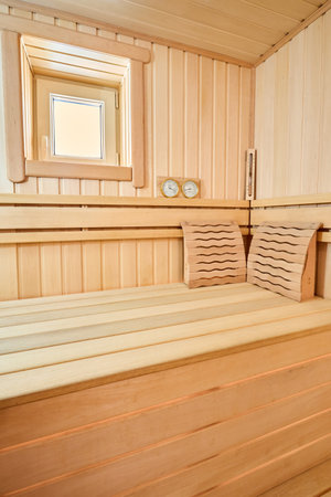 Sauna bathhouse interior with Linden Lining walls and ceiling. African oak bench, hygrometer, thermometer for traditional rejuvenation, recovery, and restoration, recreation of healthの写真素材