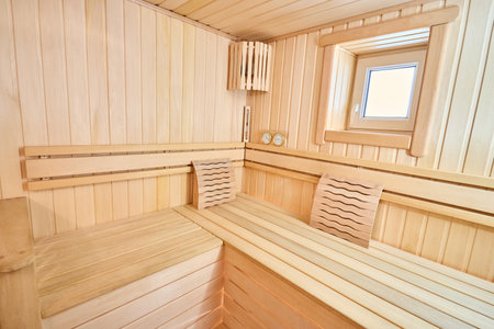 Sauna bathhouse interior with Linden Lining walls and ceiling. African oak bench hygrometer thermometer for traditional rejuvenation recovery and restoration recreation of healthの写真素材