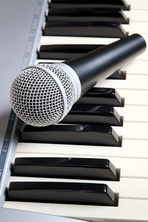 Microphone on midi piano keyboard keys. Recording studio concept. Vertical shot.の写真素材