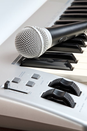 Microphone on midi piano keyboard keys. Recording studio concept. Vertical shot.の写真素材