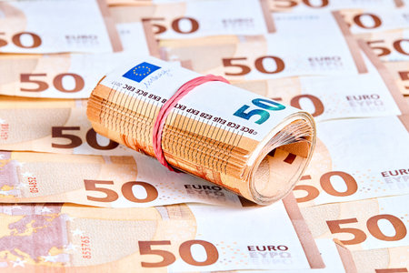 Rolled Euro 50 euro Banknotes. New 2017 fifty Euro banknotes over haphazardly heap or pile of euro bills selective focus close up horizontal shot.の写真素材