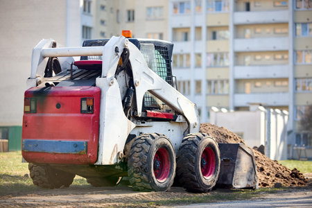 Old dirty rusty mini bulldozer digger near road over urban background with copyspace selective focus...