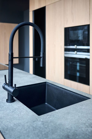 Single handle water filter kitchen faucet for reverse osmosis or water filtration system built in compact high pressure laminate HPL countertop. Kitchen undermount installation granite composite sink.の写真素材