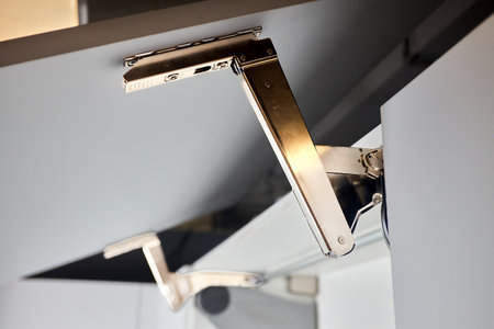 System for bi-fold fronts and facades for kitchen cabinets direct access. Element of contemporary kitchen interior closeup. Opened white horizontal kitchen cabinet sideboard with lifting mechanism.の写真素材