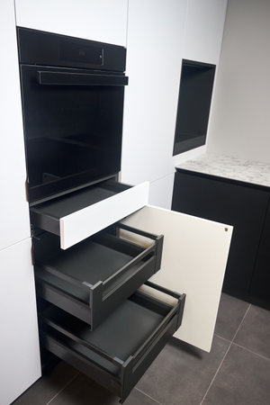 Interior of kitchen with lots of built-in upper and lower cabinets, oven, drawers and shelves. Cabinet Door Drawers with Soft Quiet Closer Damper Buffers Cushion and hidden handles.の写真素材