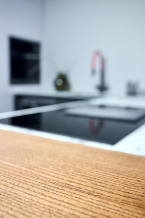 Solid ash glued timber under varnish edge corner table top selective focus macro closeup. Kitchen interior contemporary design countertop tabletop.の写真素材