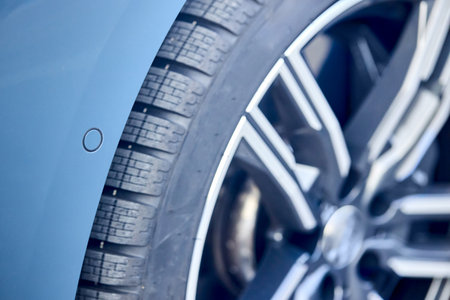 Car detailing close up alloy wheel, tires with side parking sensor on wingの写真素材