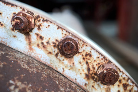 Old rusty sealing connection bolted screw connection, on manhole of industrial machine compressor or pump on chemical plant selective focus with out of focus abstract industrial background, copyspace.の写真素材