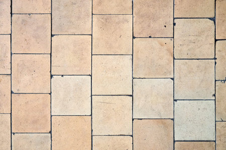 Orange brown white beige old shabby worn out floor tiles with damages cracks dirt caverns potholes...