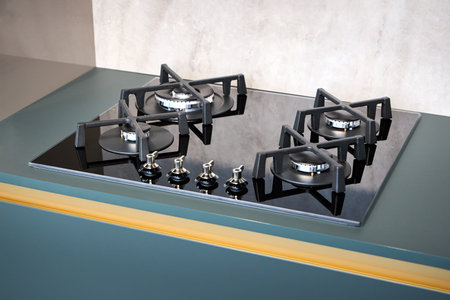 Contemporary black gas stove hob with wok burner with auto ignition knob cast iron pan supports and flame safety valve, built in compact high pressure laminate HPL countertop.