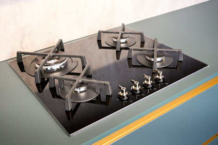 Contemporary black tempered glass easy to clean gas stove hob with wok burner with auto ignition knob cast iron pan supports and flame safety valve. Gas on glass cooktop built in countertop.