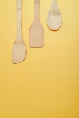 Spatulas on yellow surface.の写真素材