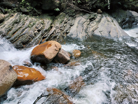 Fresh water flowing strongly down the boulders and rocks.の写真素材