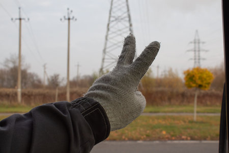 Workers hand amid pylons and power poles