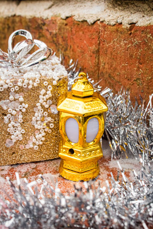 Christmas tree gift toys and lantern decorated with garland on a brick backgroundの写真素材