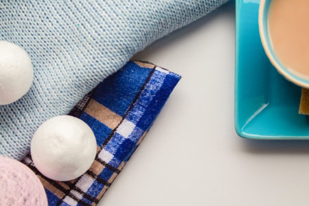 Imitation of snow on blue fabric and blue cup of coffee with milk