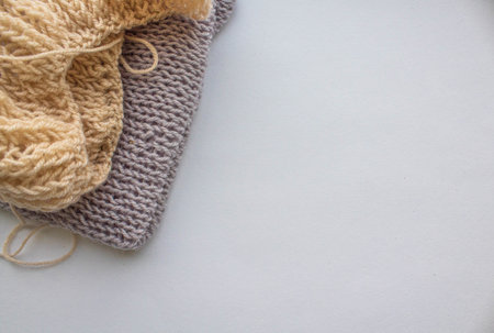 A ball of woolen thread with knitting needles and an English knitting pattern lie on a white background by the windowの写真素材