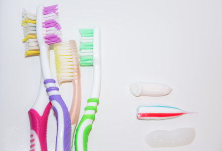 Toothbrushes of different colors next to traces of toothpasteの写真素材