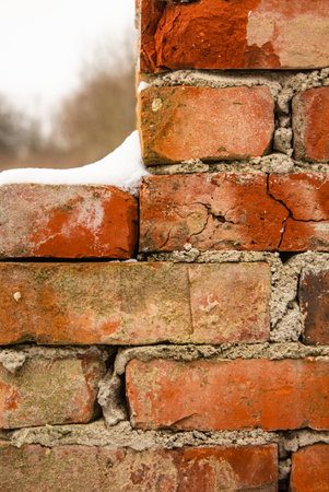 Natural brick background with a window in the snowの写真素材