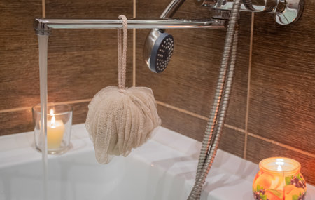Bathroom faucet with washcloth and lit candles for comfortの写真素材
