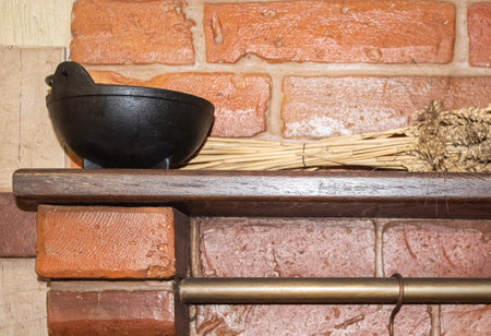 A cast-iron little black cauldron stands on a shelf on the stoveの写真素材
