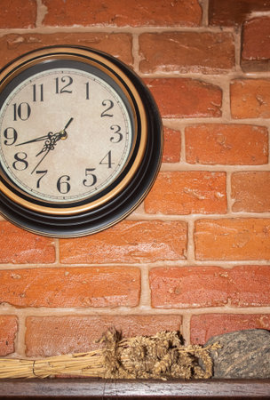Round beautiful clocks hang on a brick wall on a rustic furnaceの写真素材