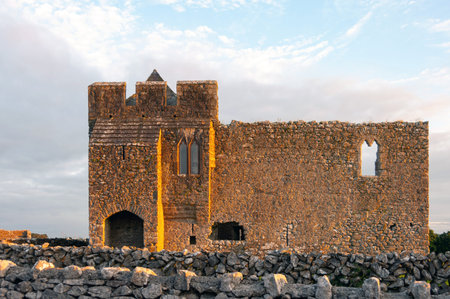 A castle with a large tower and a small window. The castle is old and has a stone wall