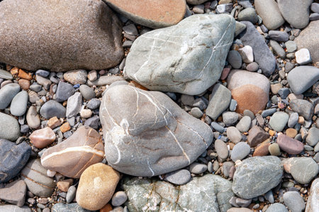 A pile of rocks with a few white lines on them. The rocks are of different sizes and colors