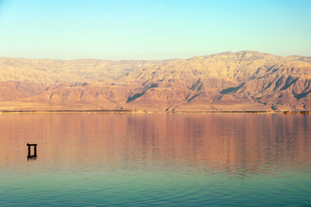 A beautiful lake with calm water and a light blue sky.の写真素材