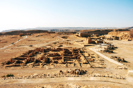 A desert landscape with a large building in the middle. The building is surrounded by a wall and...