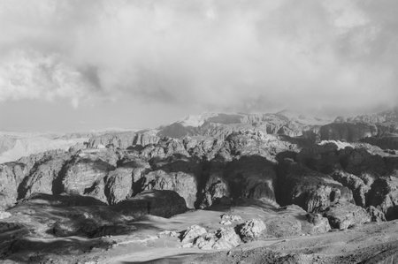 A mountain range with a cloudy sky in the background. The mountains are rocky and the sky is overcastの写真素材