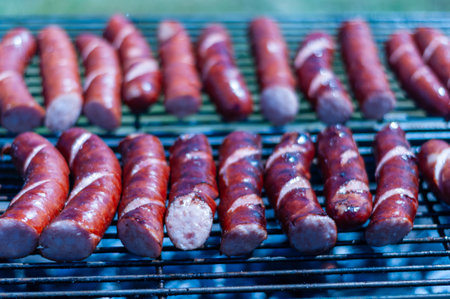 A rack of hot dogs on a grill. The hot dogs are cooked and are ready to be eatenの写真素材