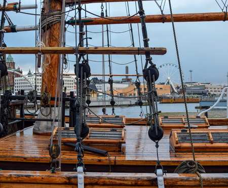 Old ship deck view from the side in the cloudy and rainy day. In the background visible city of Helsinki in Finlandの写真素材
