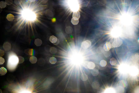 Light beams reflecting through the glass bubbles formatting the star beam shape in black background. Looks like space with the starsの写真素材