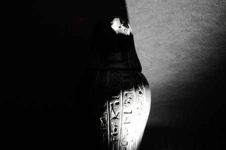 Enlightened, dusty and mysterious statue of Egypt god Horus with Falcon head in black matte backgroundの写真素材