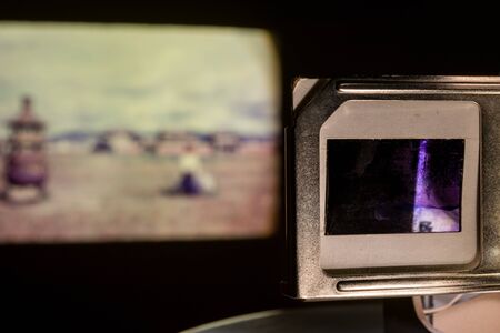 Vintage Photo Slides Projector Showing Old Photographs Slides in Dark Roomの写真素材