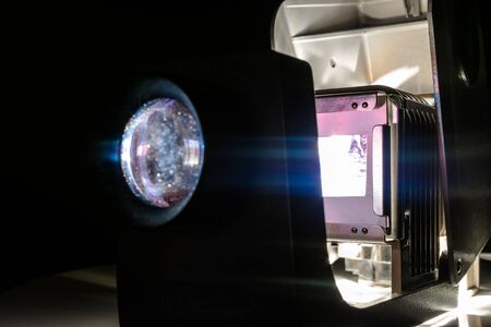 Vintage photo slides projector showing old photographs slides in dark roomの写真素材