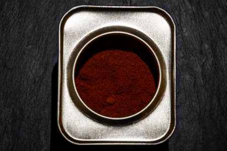 Smoked paprika powder in metal can view from top in black stone backgroundの写真素材