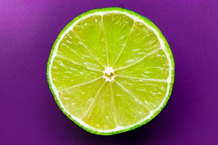 Lime, cutted in the half and placed cutted side up on purple background surfaceの写真素材
