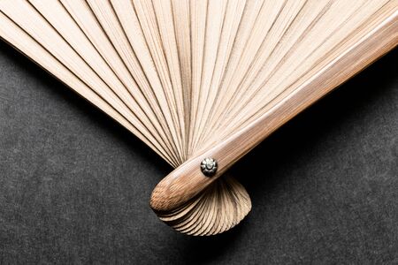 Background of evenly expanded wooden fan flasks on black blurry surfaceの写真素材