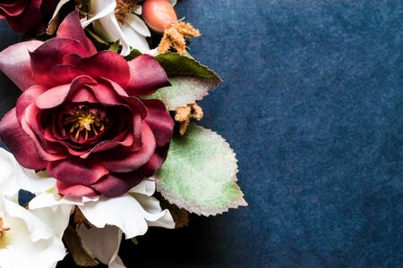 Artificial flowers on blurry blue background surface with free space. Vintage styleの写真素材