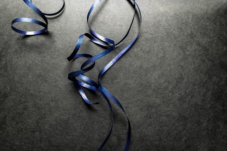 Blue wrapping ribbon placed on black surface backgroundの写真素材