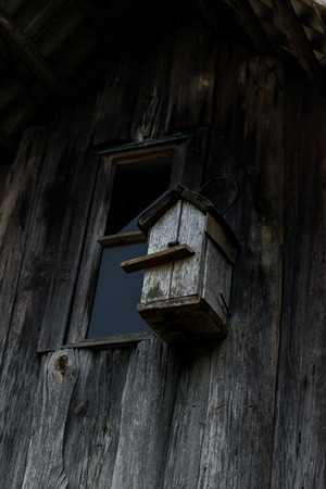 Very old gray nesting box hanging on the wooden gray barn wallの写真素材