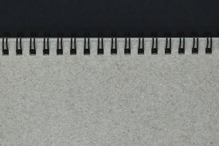 Background of grey notebook cover with black metal spirals with free copy spaceの写真素材